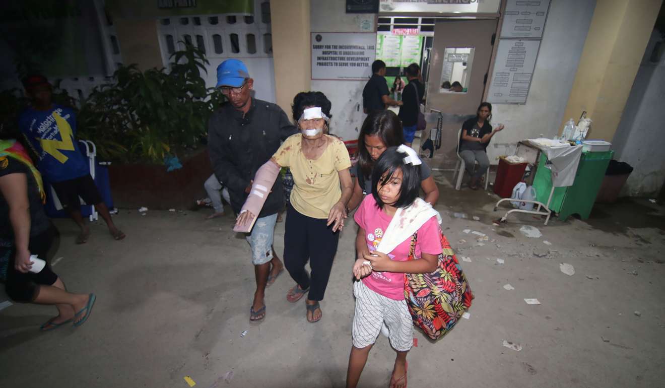 An injured woman is accompanied by family members at a hospital in Surigao City in the southern Philippines. Photo: AFP