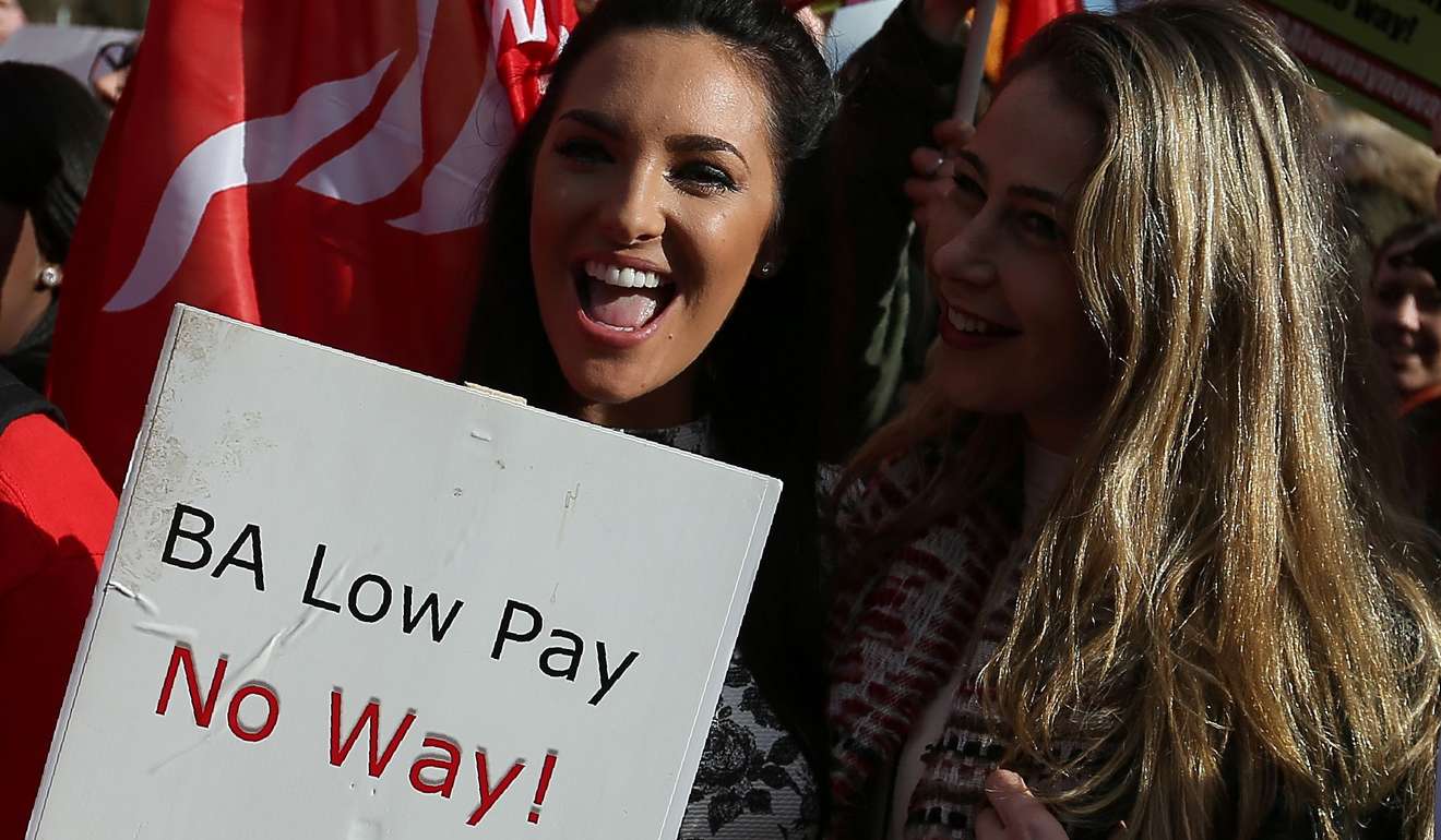 Demonstrators hold placards and wave flags as they protest against the low wages a of British Airways' staff, outside the Houses of Parliament in London on February 7. Photo: AFP