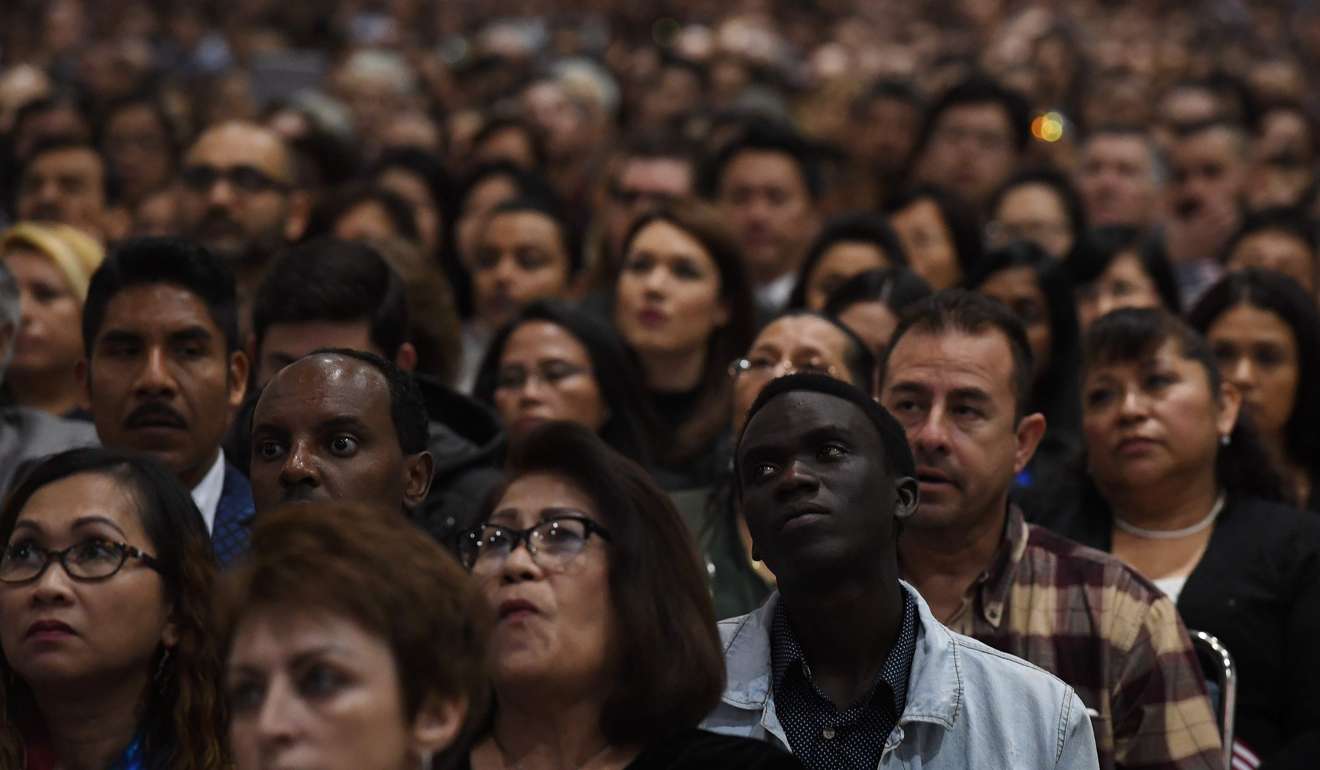 People listen to a speech before pledging allegiance to the United States of America at a naturalisation ceremony in Los Angeles last week. Photo: AFP