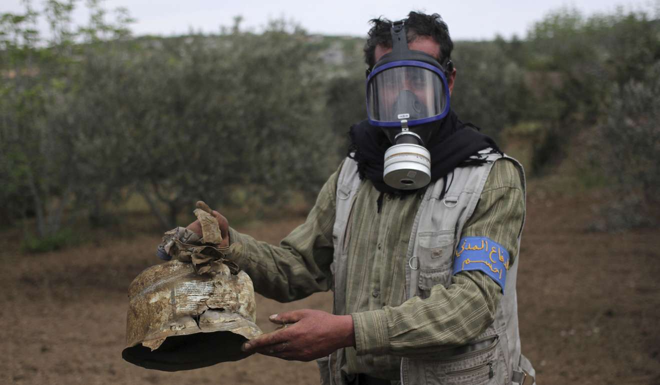 A civil defence member carries a damaged canister in Ibleen village that activists said used in a chlorine gas attack in Syria in 2015. Photo: Reuters