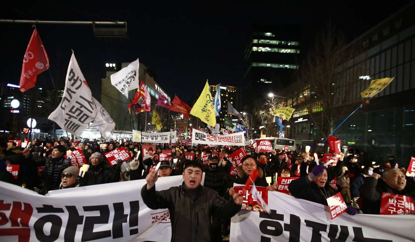 South Koreans shout slogans and hold banners reading ‘Park Geun-hye Impeachment’. Photo: EPA
