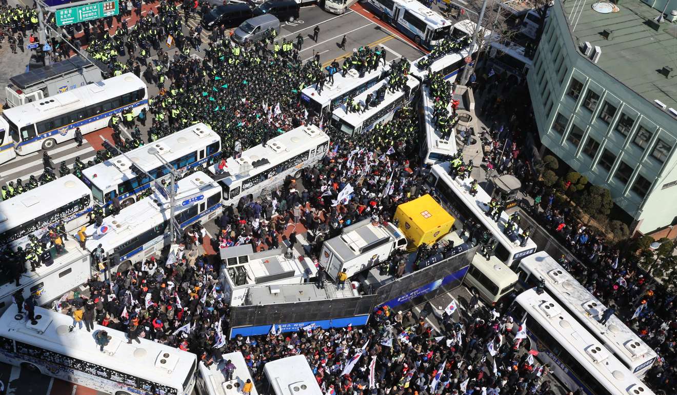 Supporters of Park Geun-hye attempt to pass a barricade of police buses. Photo: EPA