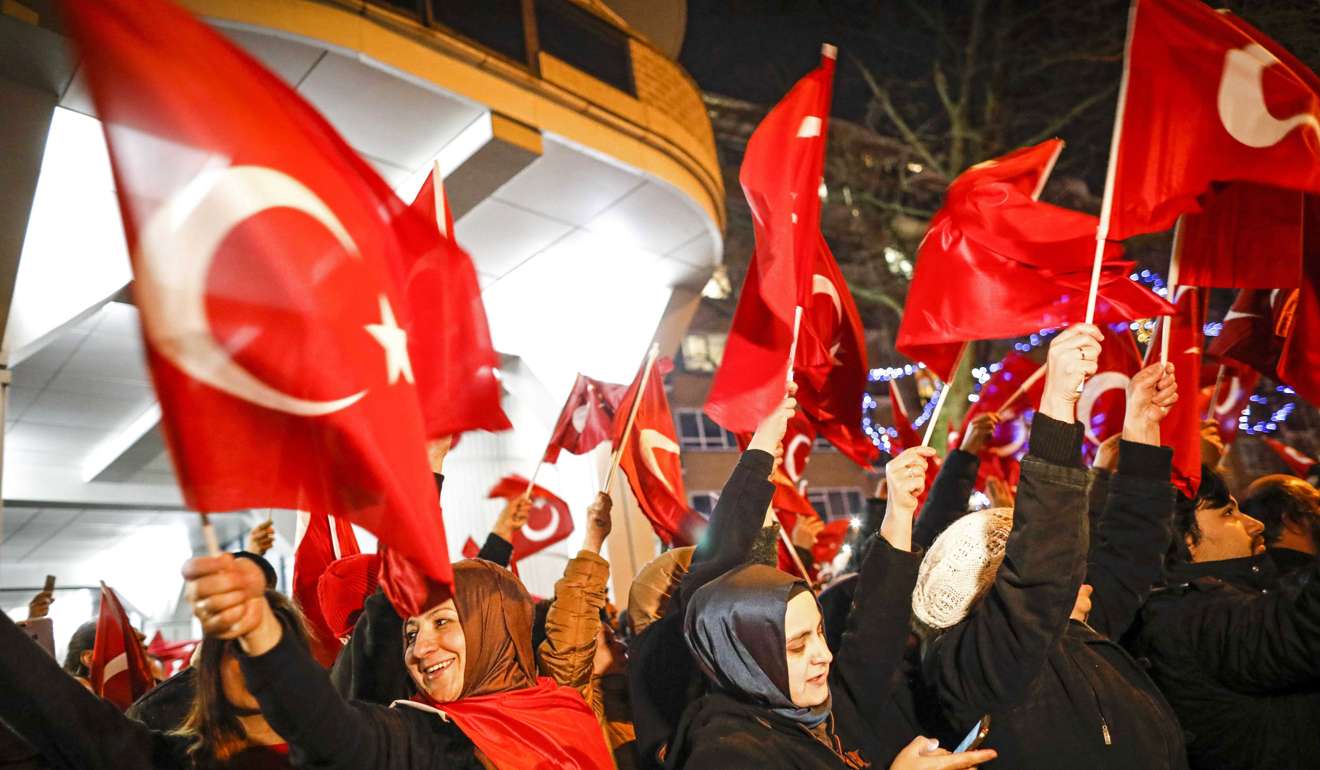 People wave Turkish flags outside the Turkish consulate in Rotterdam, the Netherlands, protesting against the Dutch government’s bar on Turkish government ministers from attending a rally in the city. Photo: EPA