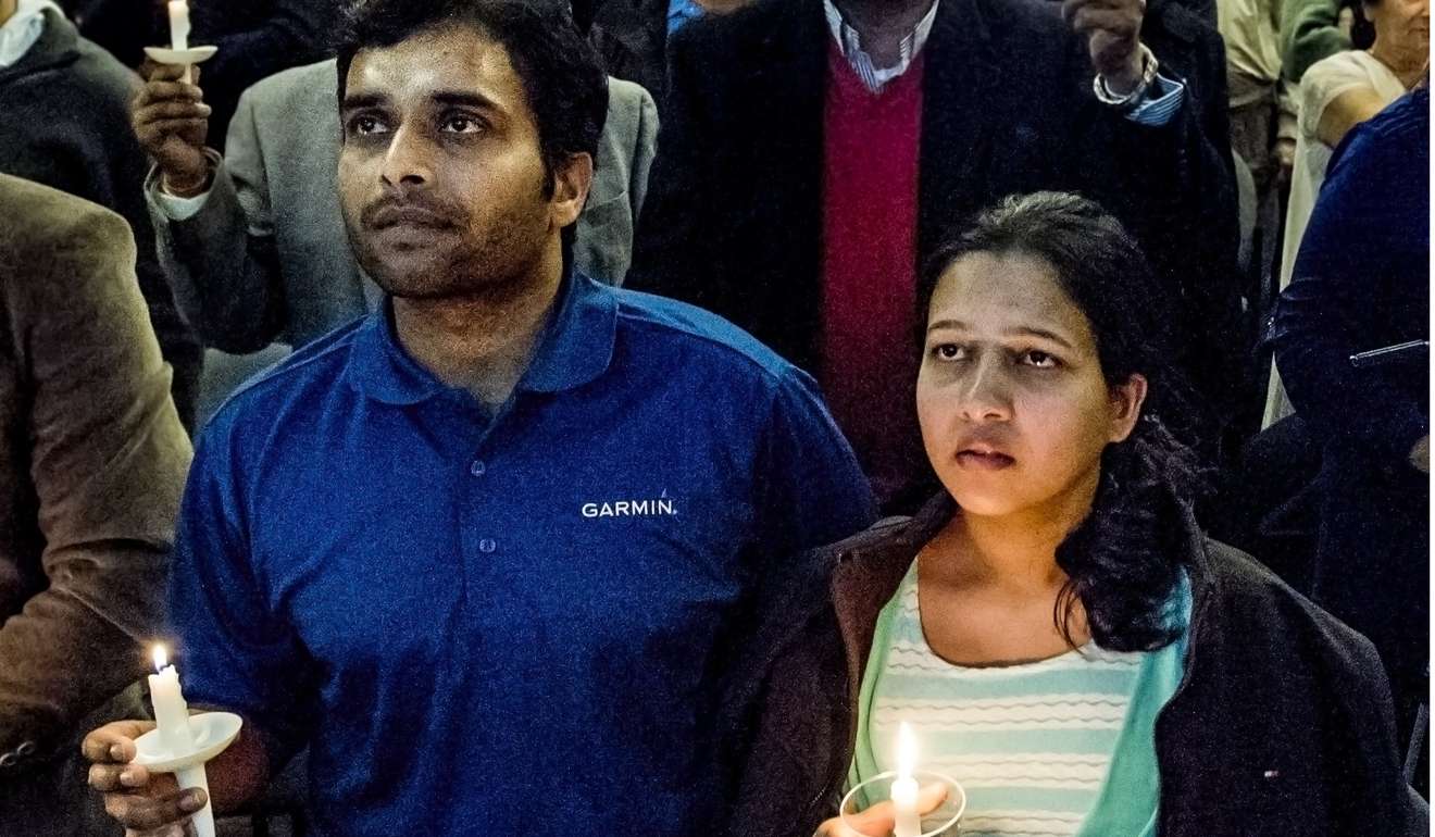 Alok Madasani, left, and his wife Reepthi Gangula hold candles during a vigil in Kansas after the deadly shooting. Photo: AP
