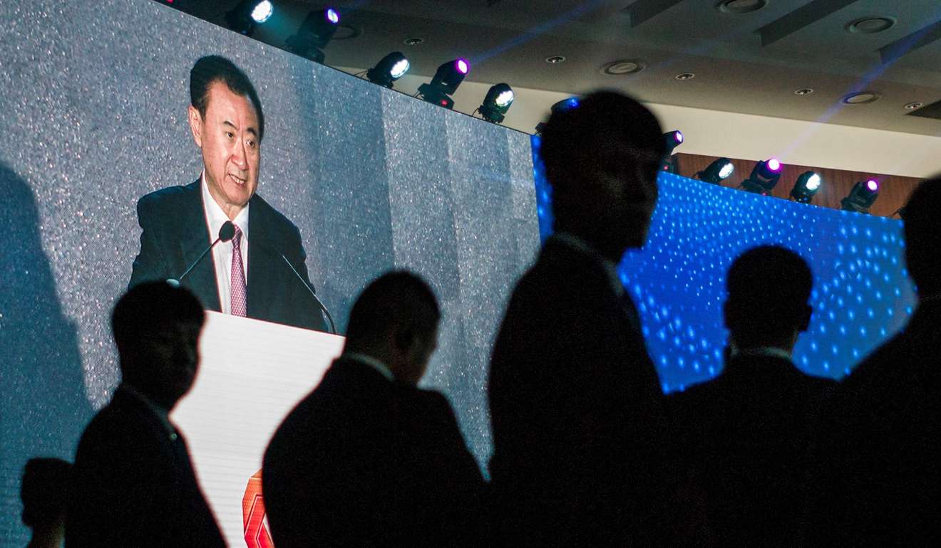 Wanda’s Wang Jianlin appearing on a big screen as he delivers a speech at an annual business summit in Beijing. Its US$1 billion bid for Dick Clark Productions has been aborted, the US firm's parent has said, following reports that it was a victim of a Chinese clampdown on overseas investments. Photo: AFP