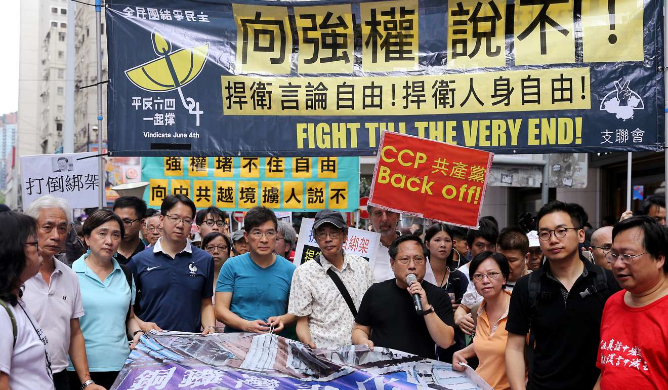 Pan-democrat lawmakers and supporters of Lam Wing-kee (centre, in white), who was among five booksellers to have gone missing, march to the central government’s liaison office from the Causeway Bay Books store to denounce cross-border abductions, last June 18. Photo: Sam Tsang