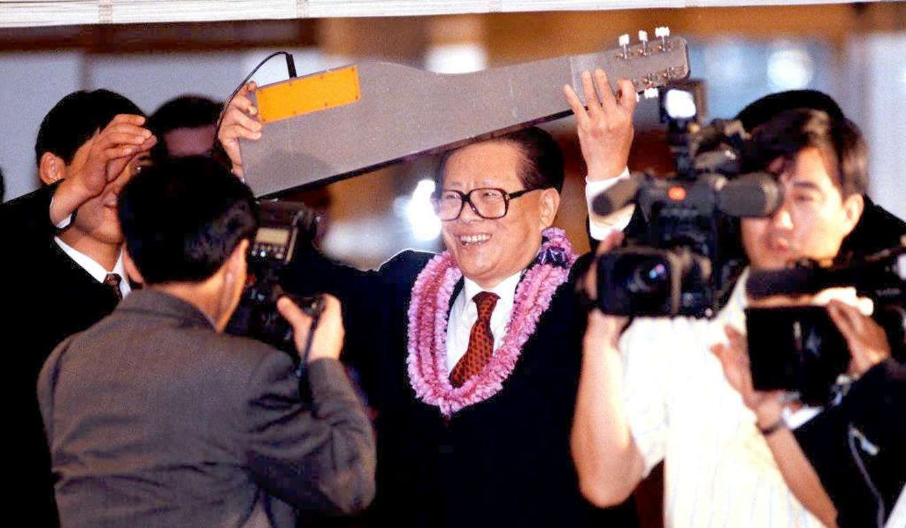 Ex-Chinese President Jiang Zemin holds a Hawaiian lap steel guitar aloft as he poses for photographers following a state dinner in Honolulu, Hawaii. Photo: AFP