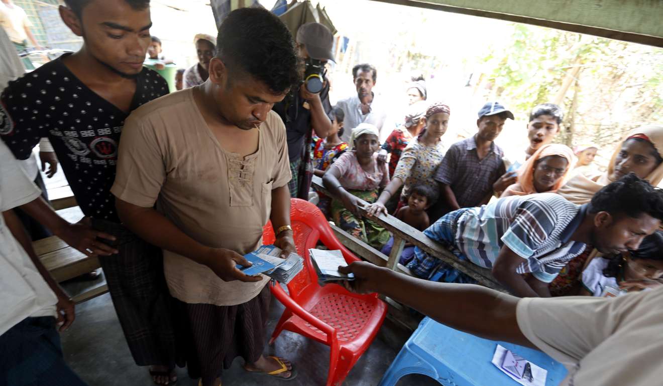 A muslim man collects the World Food Programme (WFP) cards from the people receiving relief supplies at the ThetKalPyin camp in Sittwe, Rakhine State, western Myanmar, 01 April 2017. The UN estimates 30,000 people, most of whom call themselves Rohingya and ethnic Rakhine, have fled their homes from the locked-down area of Maungdaw, since three co-ordinated attacks on police posts by unknown assailants sparked more violent conflicts in October. Photo: EPA