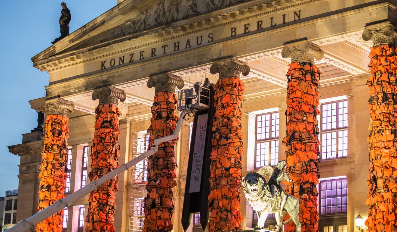Workers attach life jackets used and discarded by refugees and migrants to the facade of the 'Konzerthaus' (Concert Hall) as part of an art installation by Chinese artist Ai Weiwei in Berlin. Photo: EPA