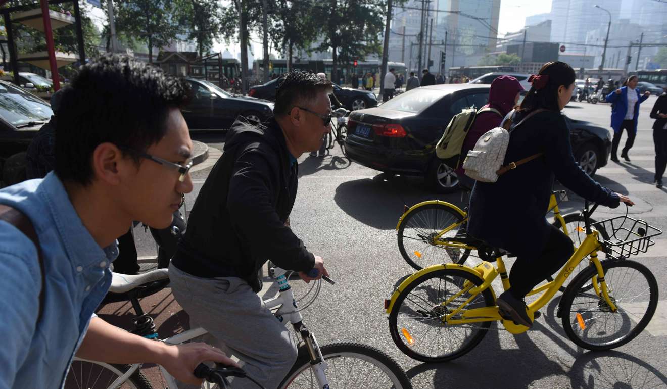 Cyclists ride on a street in Beijing. The International Monetary Fund raised its economic growth forecast for China this year and next but warned of serious longer-term problems unless it reduces its reliance on credit. Photo: AFP