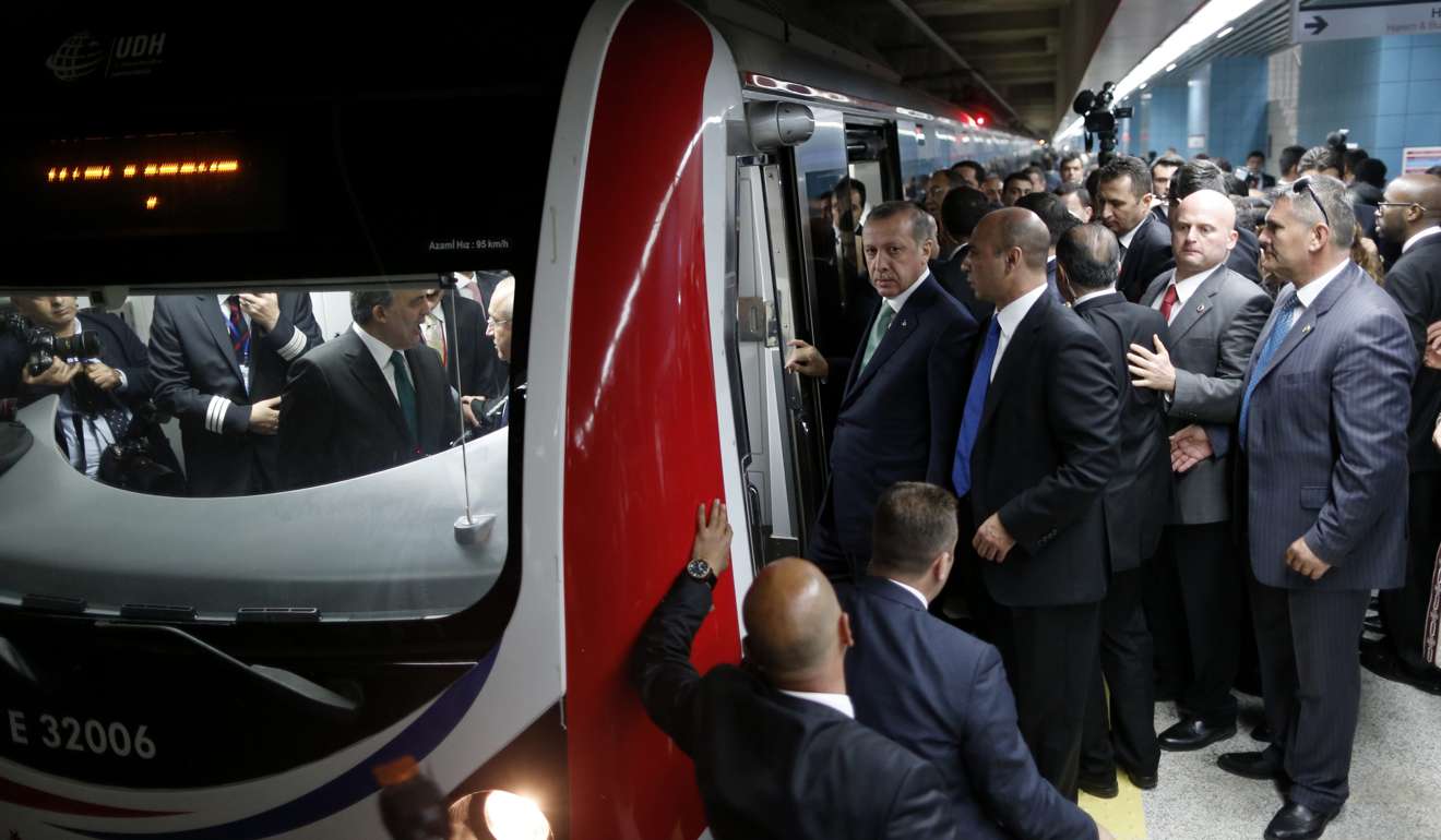 Turkish leader Recep Tayyip Erdogan, centre, arrives to test-drive a train as he attends the opening ceremony of the Marmaray railway which is a tube tunnel submerged into the Bosphorus waterway in Istanbul, Turkey. Photo: EPA