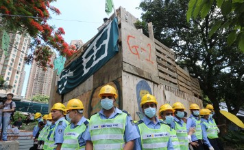 Security guards surround a wooden structure ascended by opponents of a development plan in the New Territories. Photo: Felix Wong