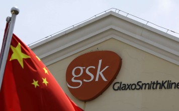 A Chinese national flag flies in front of a GlaxoSmithKline office building in Shanghai. GSK was fined a record 3 billion yuan for bribery in China in 2014. Photo: AP