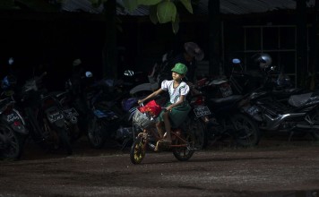 A schoolgirl rides her bike in Yangon. In Myanmar, just one fifth of the roads are paved. Photo: AFP