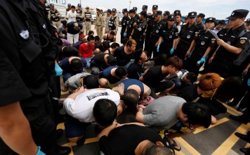 Chinese and Cambodian police surround Taiwanese and Chinese nationals suspected of telecom fraud at the International Airport of Phnom Penh in June as they await deportation to China. Photo: Reuters