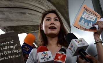 An activist displays banned charter-related material during a protest against the military crackdown on discussion and debate around the new draft constitution, in front of the Bangkok Art and Cultural Center in Bangkok on July 16, 2016. Photo: AFP