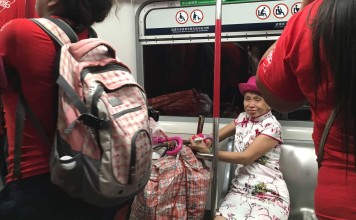 An old lady smiles as a visiting Christian group from Puerto Rico sings in the carriage of an MTR train. Photo: Kylie Knott