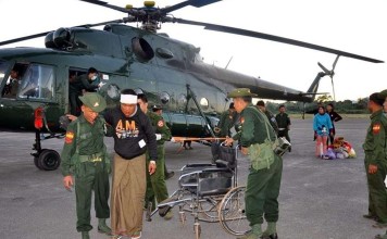 Soldiers help people injured in fighting in Lashio, northern Myanmar, on Sunday. Photo: EPA