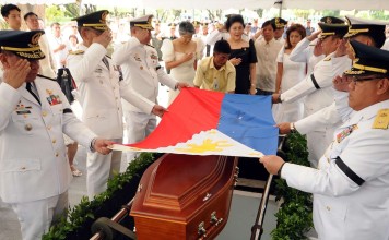 Members of the late dictator Ferdinand Marcos led by former first lady Imelda Marcos (in black) watch as military officers salute as they place a national flag at the coffin of the late president during the burial at the heroes' cemetery in Manila. Photo: AFP / Office of Governor Imee Marcos