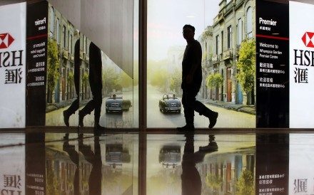 A passer-by passes HSBC advertising board in Hung Hom. Photo: Felix Wong