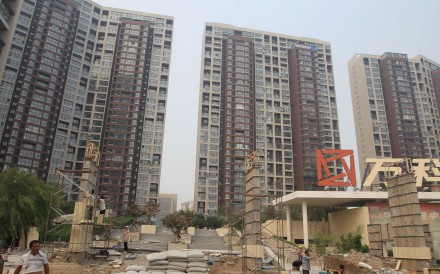 The entrance to a residential area is under renovation in Tianjin a year after the blasts. Many windows in these buildings were damaged in last year's explosions. Photo: Simon Song
