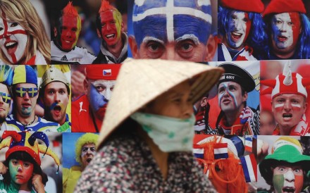 A cyclist in Hanoi rides past an advert for a European football tournament. Illegal gambling, such as on football competitions, is popular in Vietnam. Photo: AFP