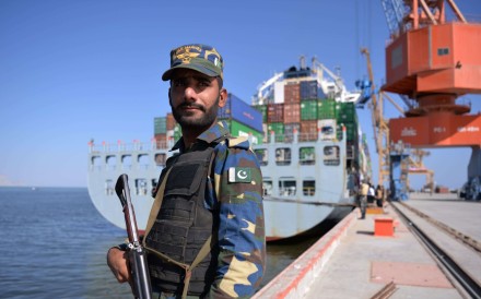 A Pakistani naval personnel stands guard beside a ship carrying containers during the opening of a trade project in Gwadar port, some 700km west of Karachi. The port is a key component of a trade route linking the Gwadar to the Chinese city of Kashgar. Photo: AFP