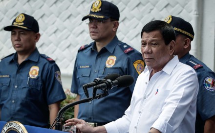 Philippine President Rodrigo Duterte flanked by police. Photo: EPA