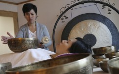 Jasmine Hui (standing) and Jennifer Tang (lying down), founders of Sound Therapy, demonstrate the singing bowls at their Wan Chai centre. Photo: Dickson Lee