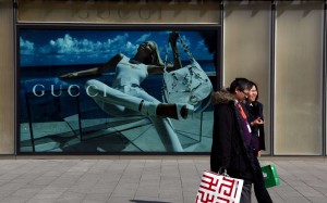 Shoppers walk past a billboard for fashion label Gucci in Beijing. The Italian luxury goods powerhouse is considering adding China to the 28 countries and regions where it already sells through its website. Photo: Reuters