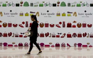 A shopper walks past a boutique outlet under construction covered by its advertisement board at a shopping mall in Beijing. Chinese retail spending is being tipped to overtake the US this year. Photo: AP