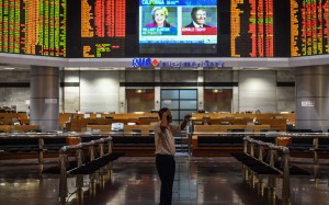 A trader in Kuala Lumpur in front of an electronic board showing stock movements during the US presidential vote. Photo: AFP