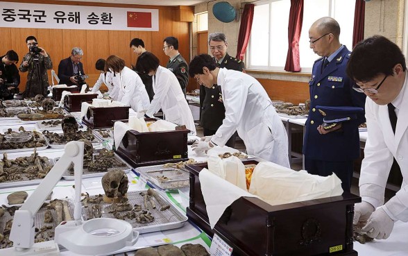 The remains of Chinese soldiers killed in the Korean war are prepared before being placed in coffins during a last rites ceremony at a temporary columbarium in Paju, South Korea, yesterday. The white-coated members of South Korea’s Agency for KIA (Killed in Action) Recovery and Identification were watched by Chinese military officers. The war raged from 1950 to 1953. Photo: Reuters The remains of Chinese soldiers killed in the Korean war are prepared before being placed in coffins during a last rites ceremony at a temporary columbarium in Paju, South Korea, yesterday. The white-coated members of South Korea’s Agency for KIA (Killed in Action) Recovery and Identification were watched by Chinese military officers. The war raged from 1950 to 1953. Photo: Reuters