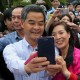 A visitor poses with Chief Executive Leung Chun-ying for a picture during the Government House annual open day in Central. Photo: Felix Wong