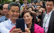 A visitor poses with Chief Executive Leung Chun-ying for a picture during the Government House annual open day in Central. Photo: Felix Wong