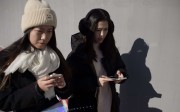 Two young women using their smartphones in Beijing. Photo: AFP