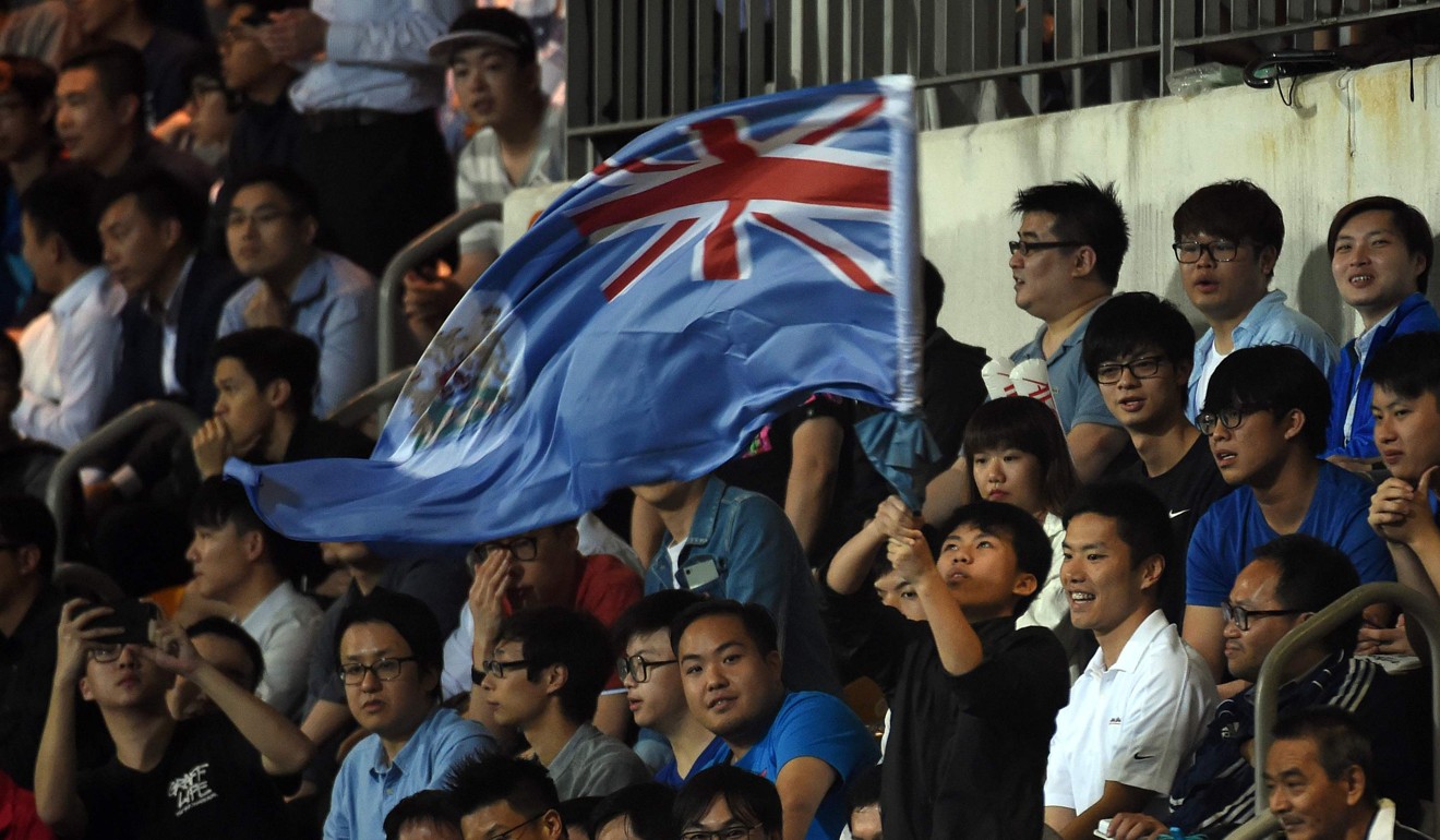 A fan (C) of Hong Kong's Eastern waves the old British colonial flag against Guangzhou. Photo: AFP
