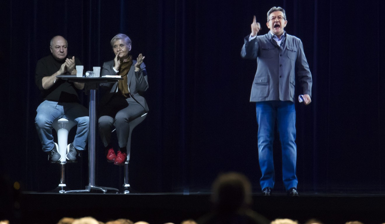 A hologram of Jean-Luc Melenchon is displayed on stage as audience members look on, during a campaign rally in Saint-Denis, outside Paris. Photo: EPA