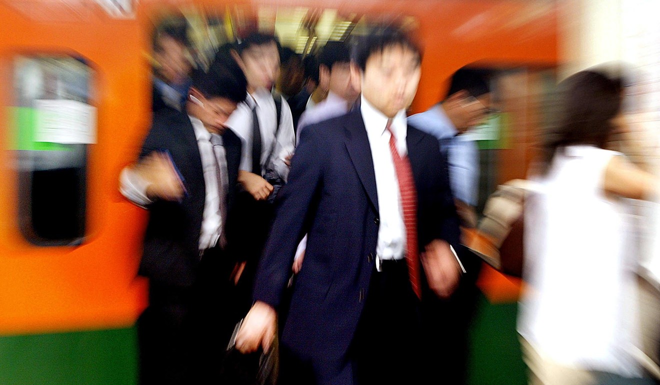 Commuters leaving a crowded train at a Tokyo station. Photo: AFP