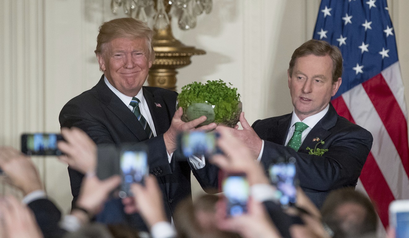 US President Donald Trump, left, and Irish Prime Minister Enda Kenny, right, hold up a bowl of Irish shamrocks during a St Patrick's Day reception in the East Room of the White House in Washington on March 16. Photo: AP