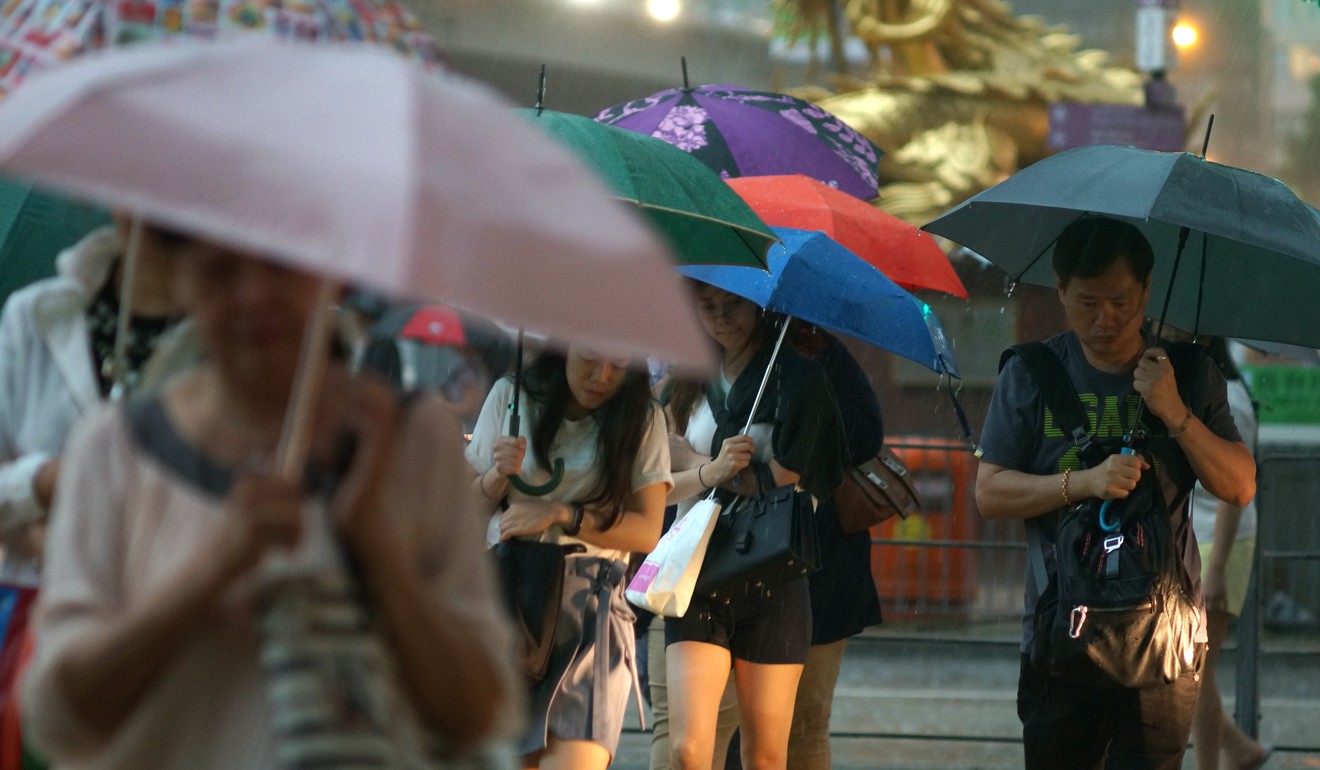 People brave the heavy rain in Causeway Bay on Wednesday morning. Photo: Fung Chang