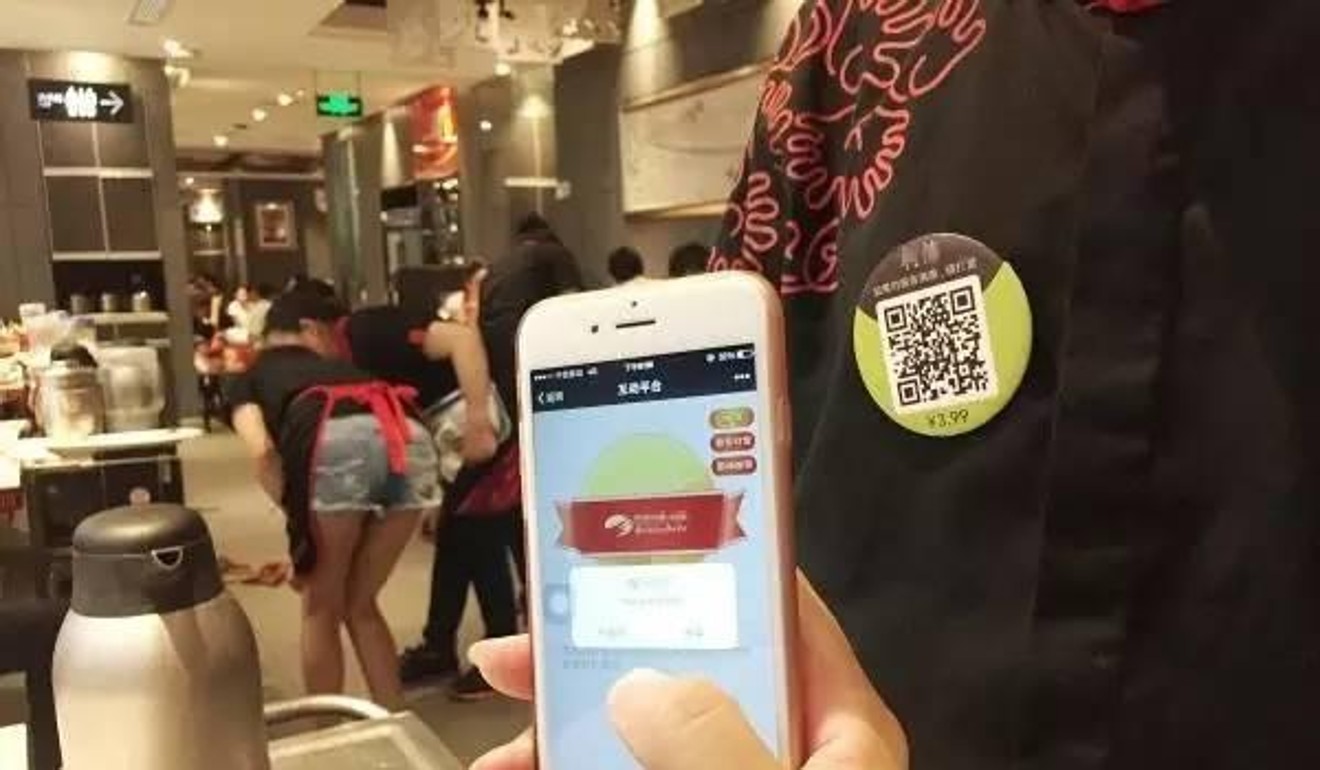 A restaurant in China has pinned barcode tags to the chests of its waiters and waitresses to encourage tipping. Photo: Handout