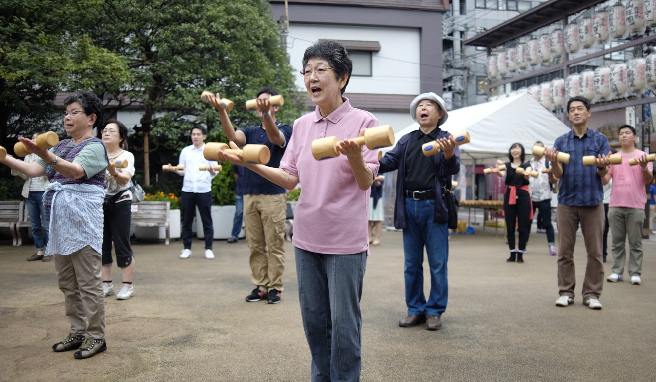 Elderly people work out with wooden dumbbells in the grounds of a temple in Tokyo last September 19, to mark Japan’s “Respect for the Aged” day. Photo: AFP