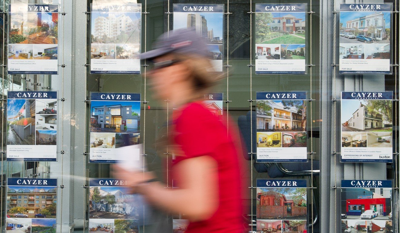 A person walks past property listings in the window of a real estate agency in Melbourne. Photo: Xinhua