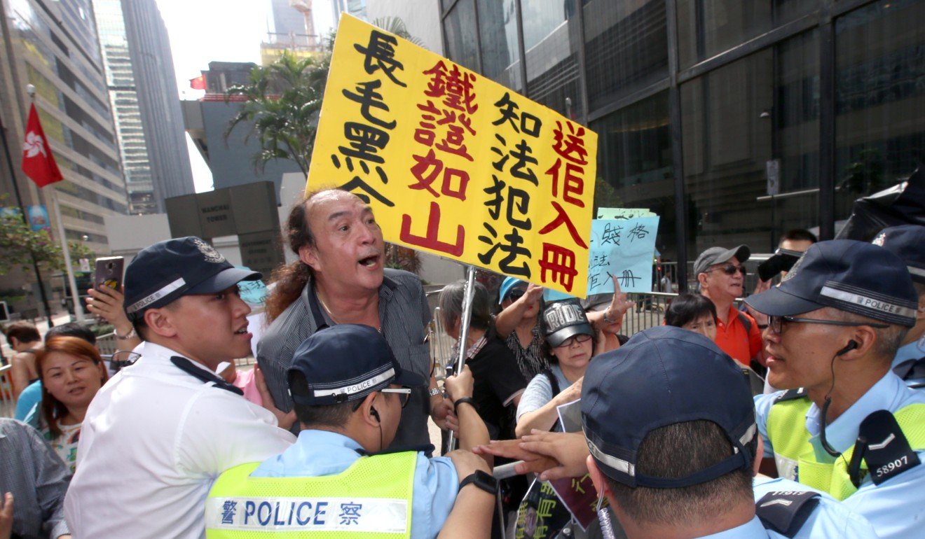 Protesters wave signboards admonishing Leung outside the court.Photo: David Wong