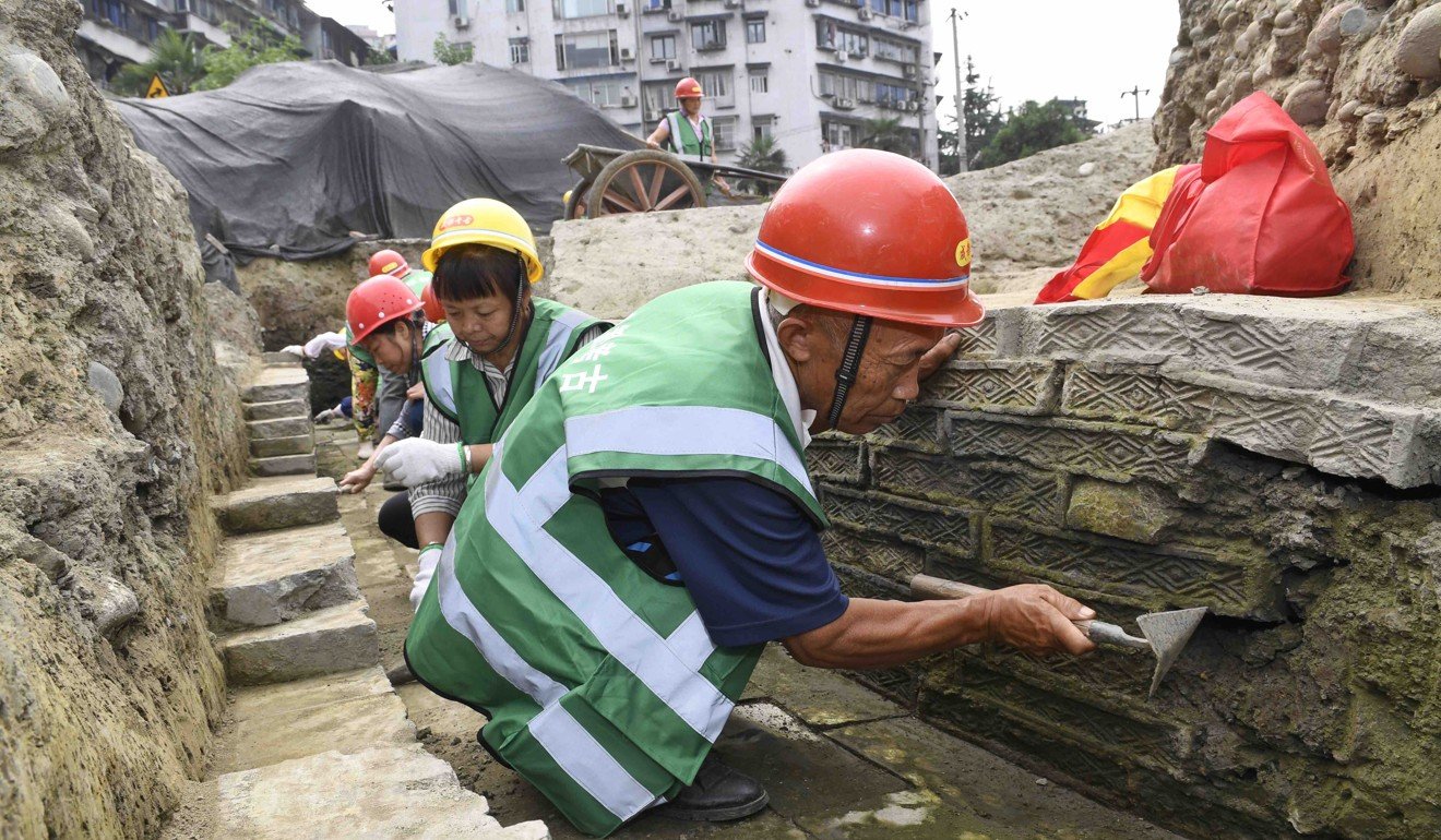 Workers clean a ceramic wall at the excavation site of the “lost” Fugan Temple in Chengdu. Photo: Xinhua