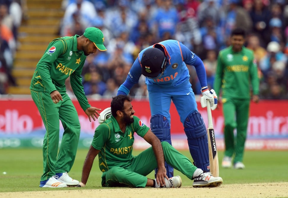 Singh consoles injured Pakistan player Imad Wasim during their ICC Champions trophy match. Photo: AFP