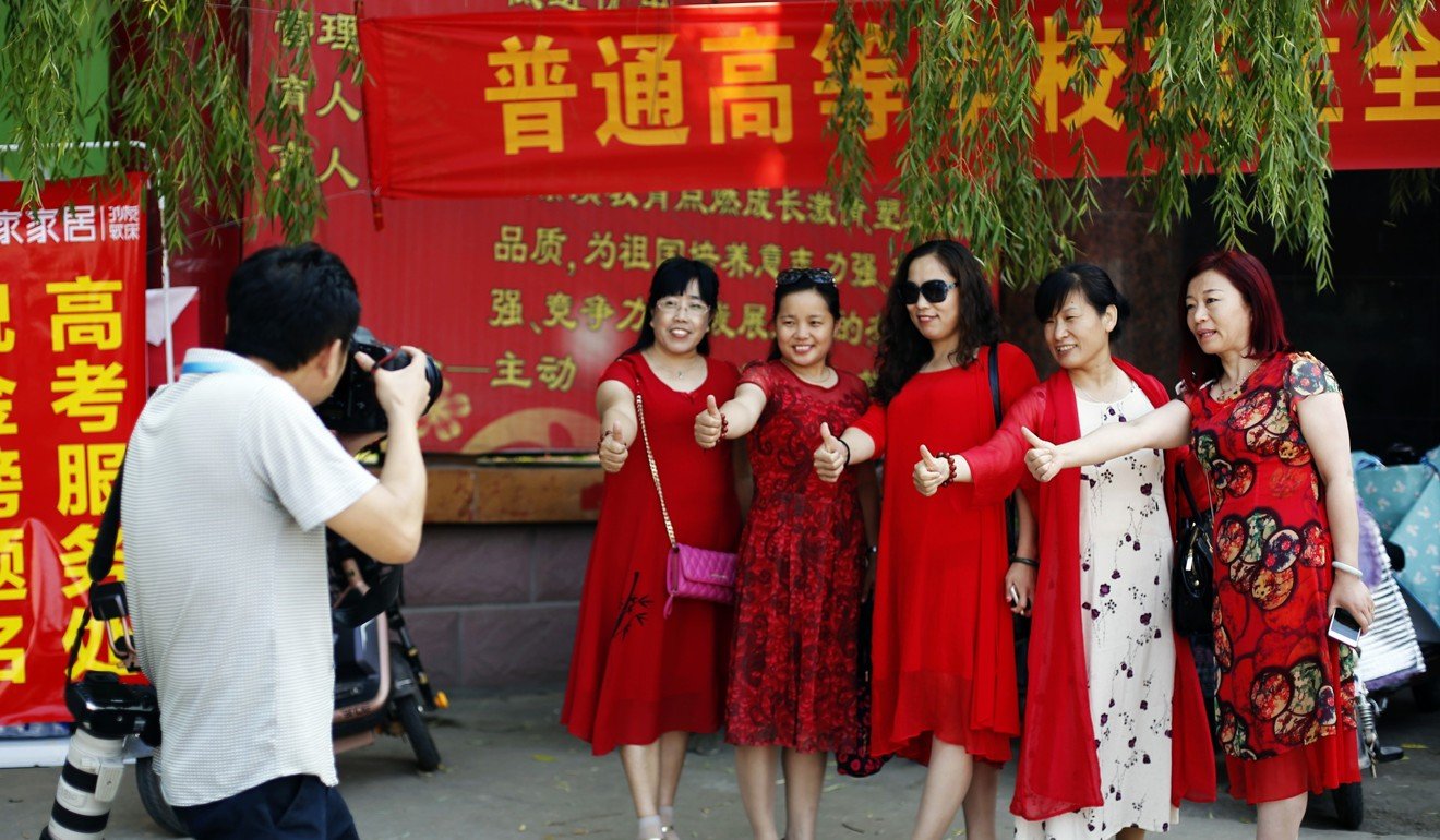 Parents of candidates for the national college entrance examination pose for photos outside the exam site in Hengshui, north China's Hebei Province, June 7, 2017. Photo: Xinhua
