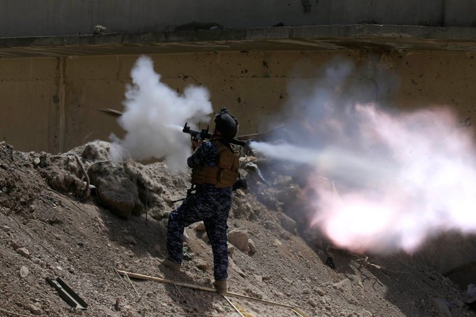 An Iraqi federal policeman fires an RPG toward ISIS militants during a battle in western Mosul. Photo: Thomson Reuters