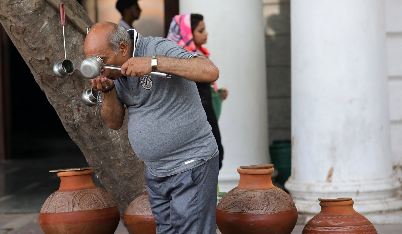 An Indian man drinks water from the public earthen clay water pots on a hot summer day in New Delhi, India. More deadly heat waves are seen taking place due to global warming. Photo: EPA